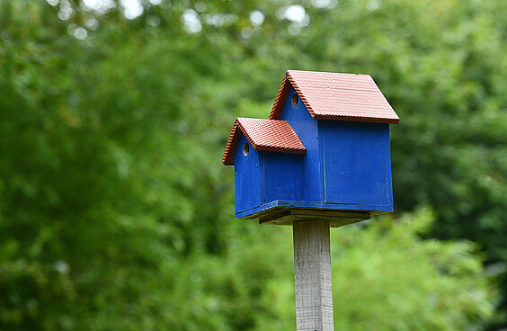 Blauer Nistkasten fuer Voegel aus Holz