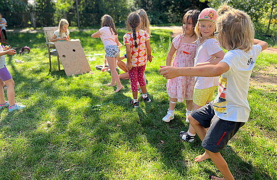 Kinder stehen in einer Schlage um an einem Brettspiel mitzuspielen