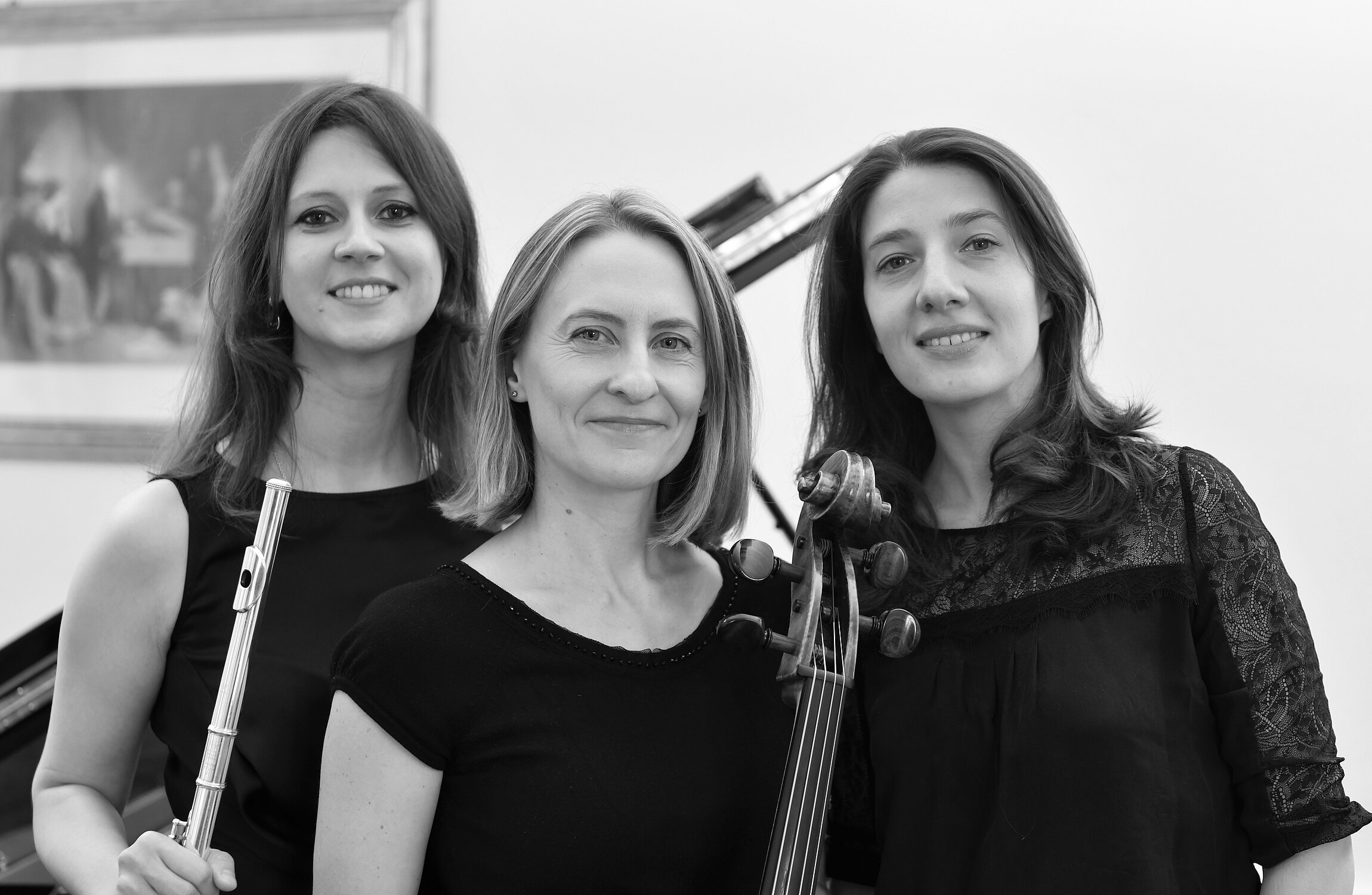 Drei Musikerinnen Anna Mazurek (Cello), Liudmyla Polova (Klavier) und Maruta Staravoitava (Floete) vor einem Flügel stehend
