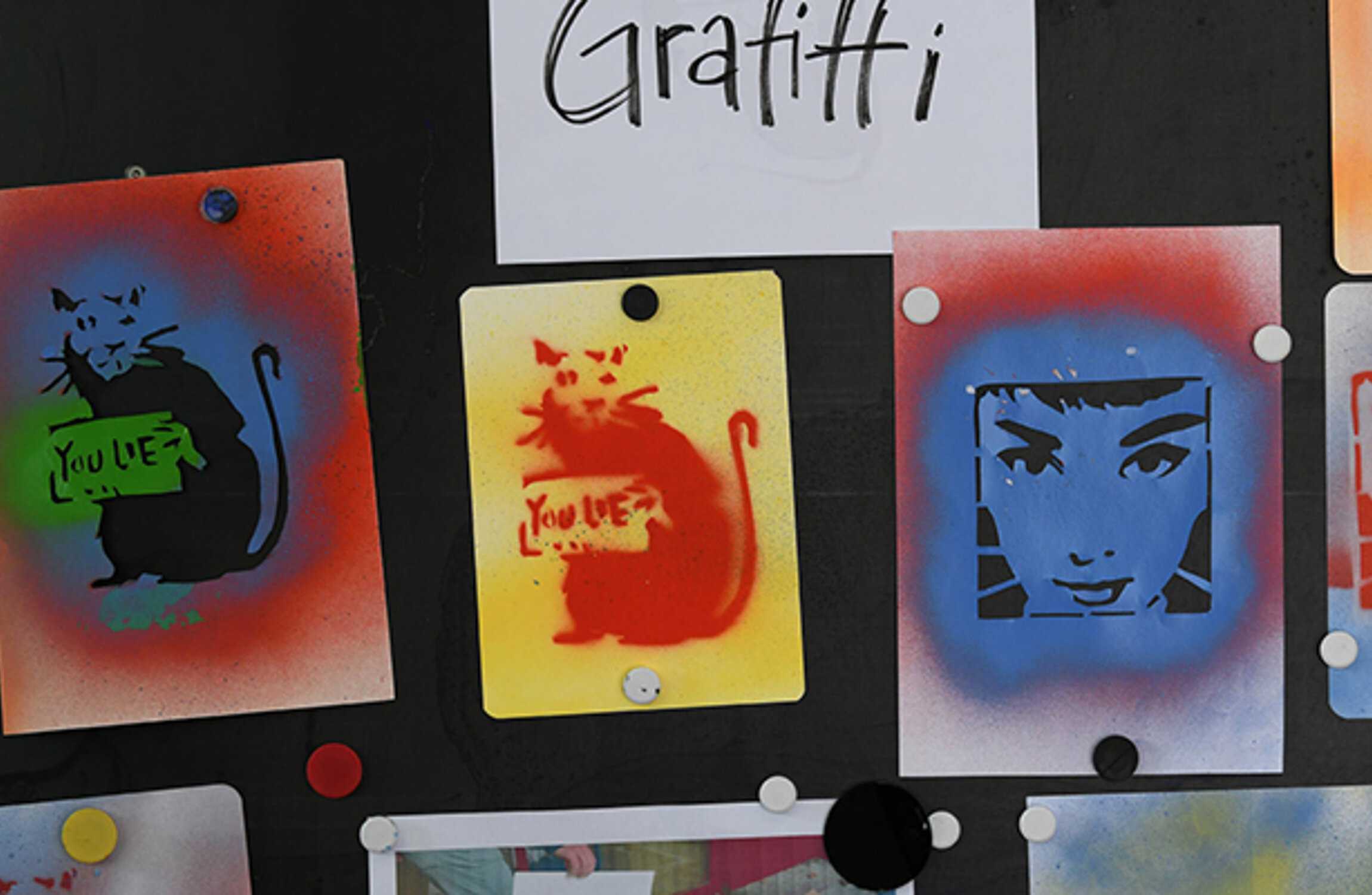 Mehrere Graffiti Bilder, ausgestellt an einer Wand