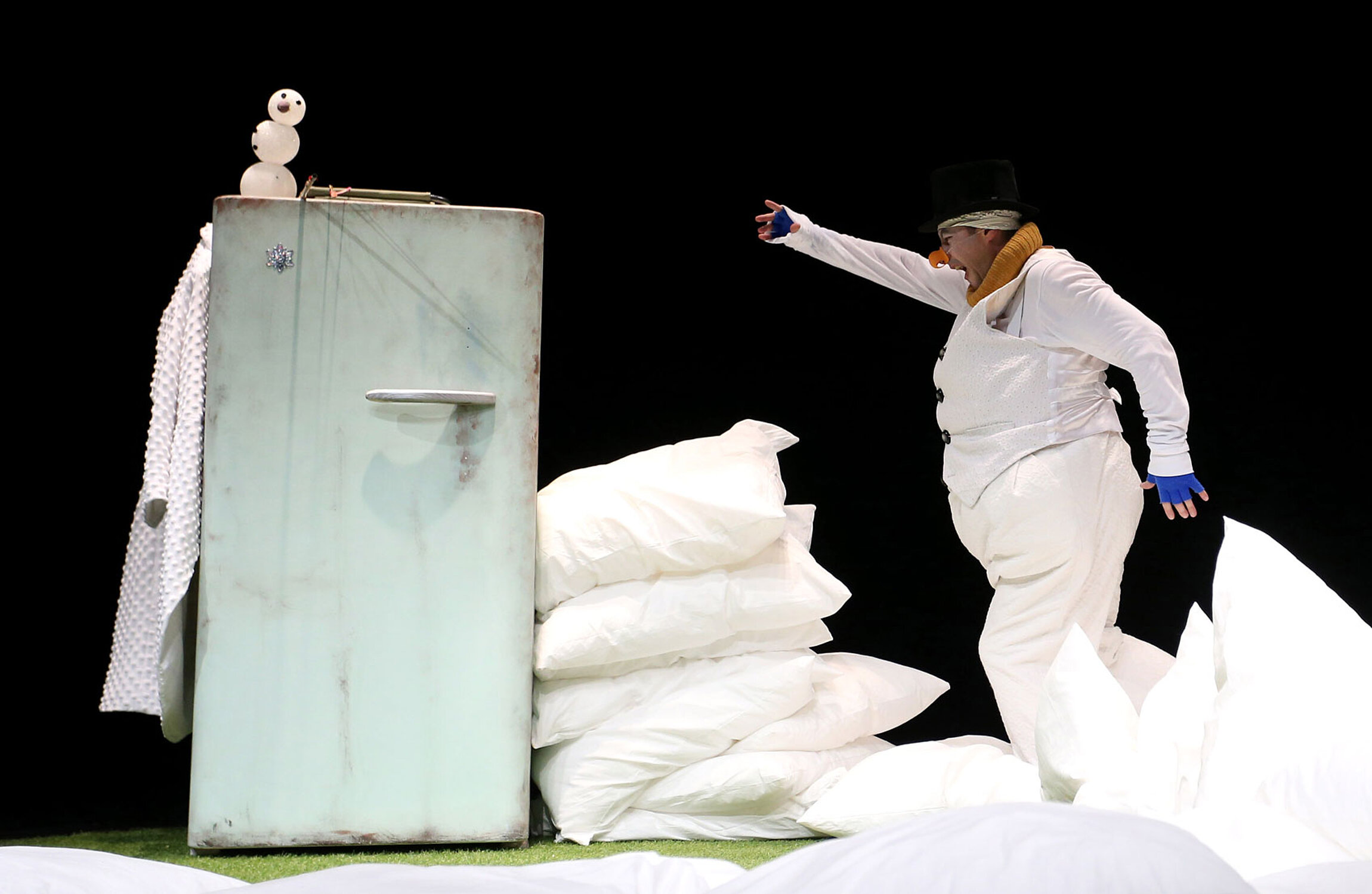 Schauspieler im Schneemannkostüm mit Kissen und einem Kühlschrank