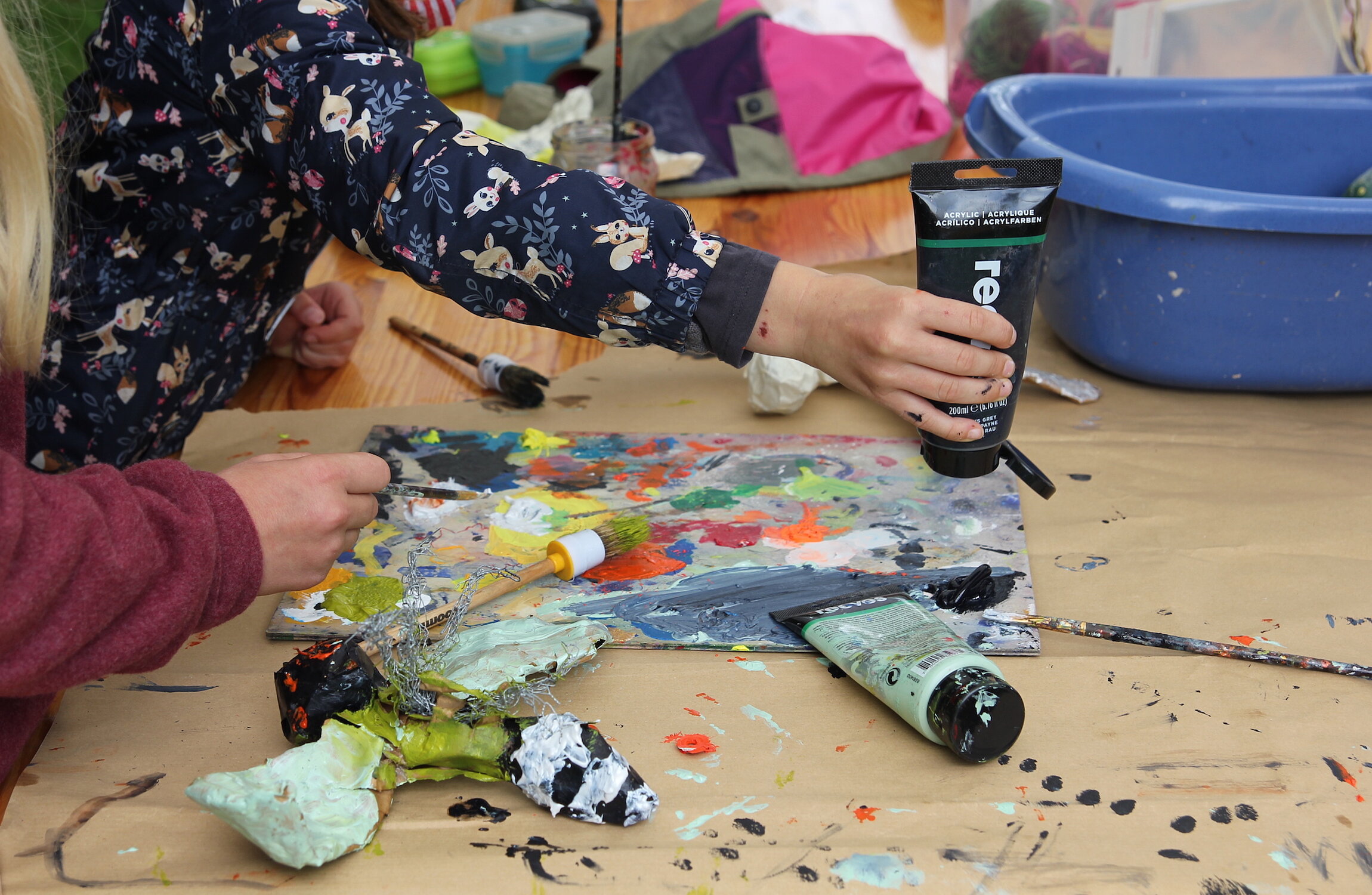 Kinder verteilen Farbe auf einer Palette 