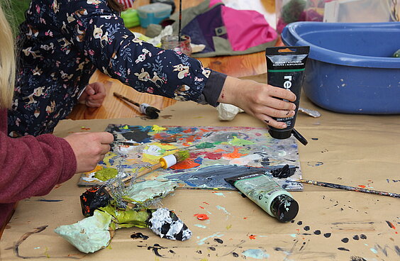 Kinder verteilen Farbe auf einer Palette 