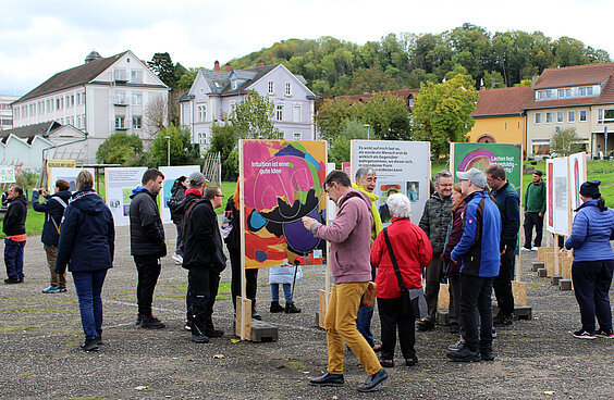 Besucher:innen vor den Ausstellungstafeln der Ausstellung "Der Mensch macht glücklich"