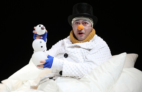 Schauspieler im Schneemannkostüm mit kleinem gebasteltem Schneemann